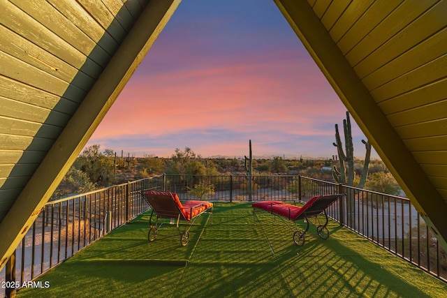 yard at dusk featuring a balcony