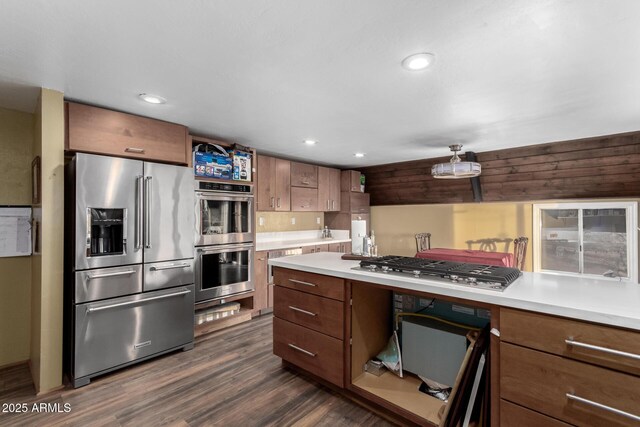kitchen featuring recessed lighting, dark wood-style floors, light countertops, brown cabinets, and appliances with stainless steel finishes
