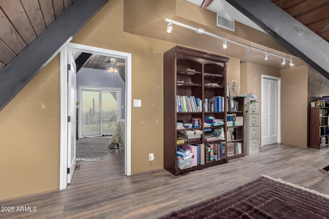 additional living space with vaulted ceiling, a textured wall, a ceiling fan, visible vents, and wood finished floors