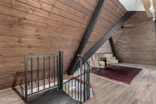 bonus room featuring vaulted ceiling with beams, wooden walls, ceiling fan, wooden ceiling, and wood finished floors