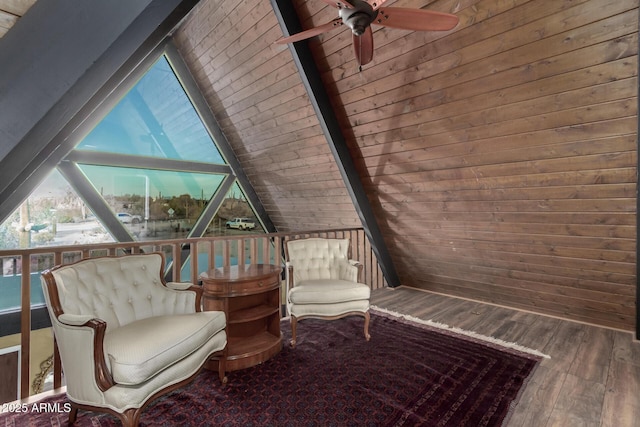 unfurnished room with wooden walls, ceiling fan, vaulted ceiling with beams, and wood finished floors