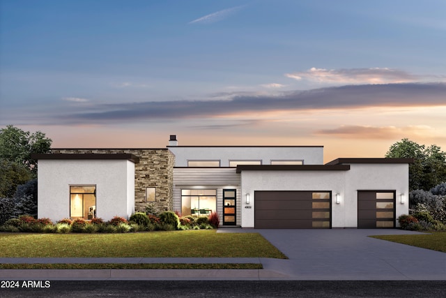 contemporary house featuring a garage and a yard