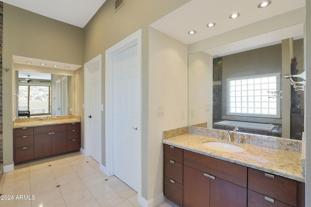 bathroom with tile patterned floors, plenty of natural light, vanity, and a washtub