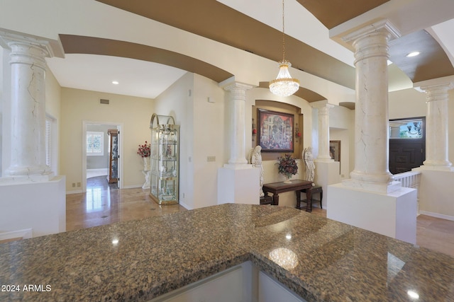 kitchen with decorative light fixtures and dark stone countertops