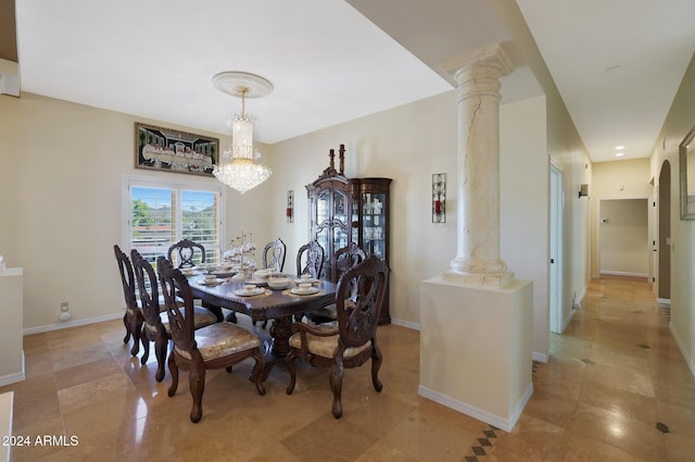 dining area featuring decorative columns and an inviting chandelier