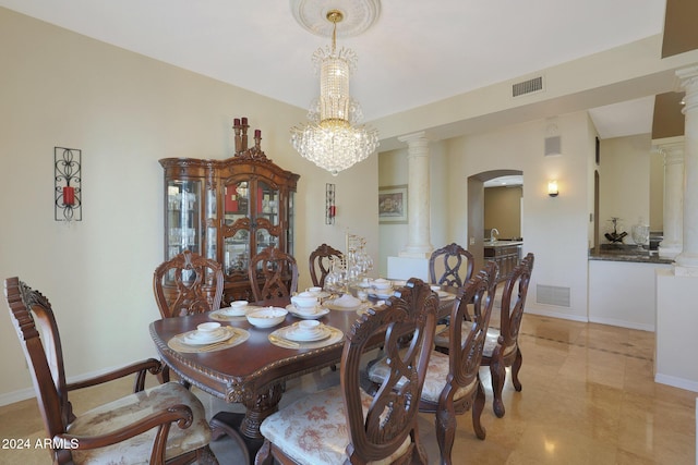 dining area featuring a notable chandelier and ornate columns