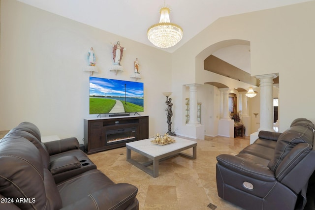 living room with a notable chandelier, lofted ceiling, and decorative columns