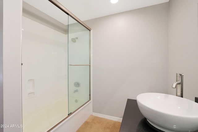 bathroom with enclosed tub / shower combo and sink