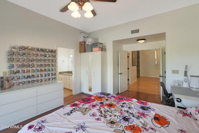 bedroom featuring ensuite bath, ceiling fan, and wood-type flooring