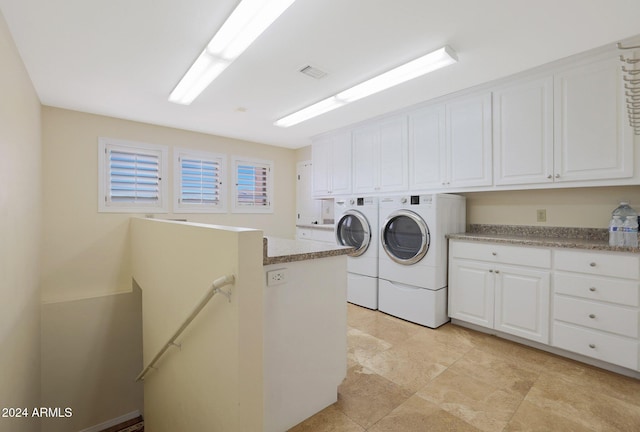 clothes washing area with cabinets and independent washer and dryer