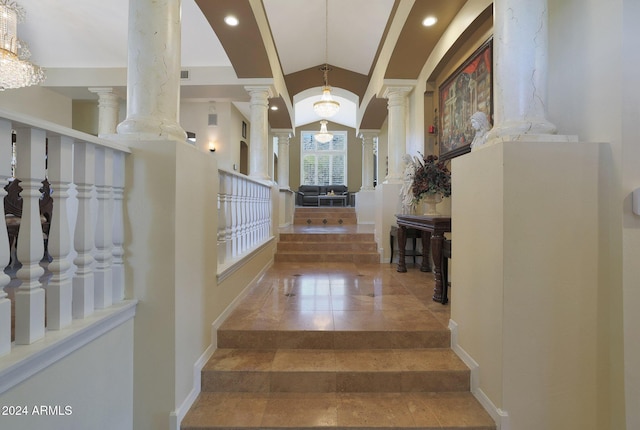 stairs with ornate columns and a chandelier