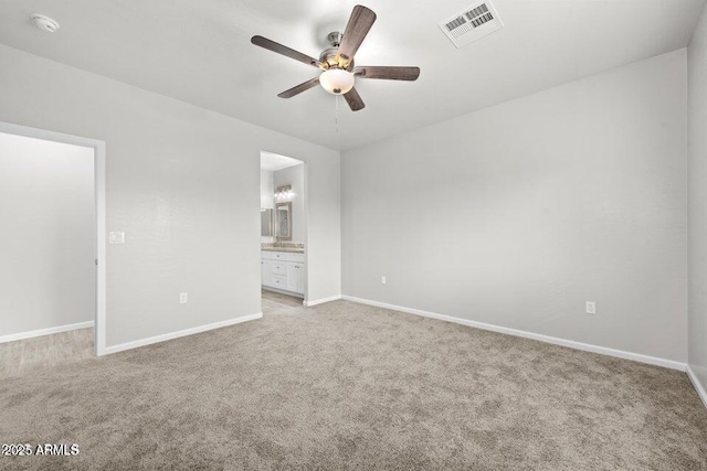 unfurnished bedroom featuring connected bathroom, light carpet, and ceiling fan