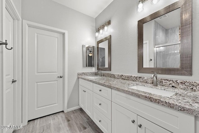 bathroom with a shower with door, vanity, and hardwood / wood-style flooring