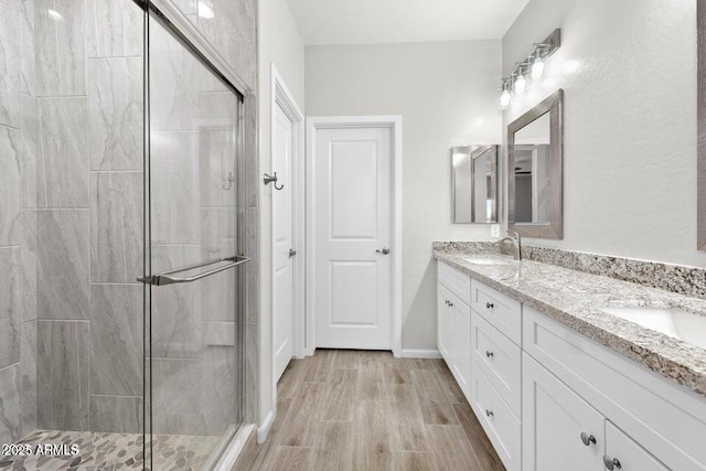 bathroom featuring a shower with door, vanity, and hardwood / wood-style flooring