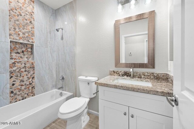 full bathroom with toilet, tiled shower / bath, and vanity