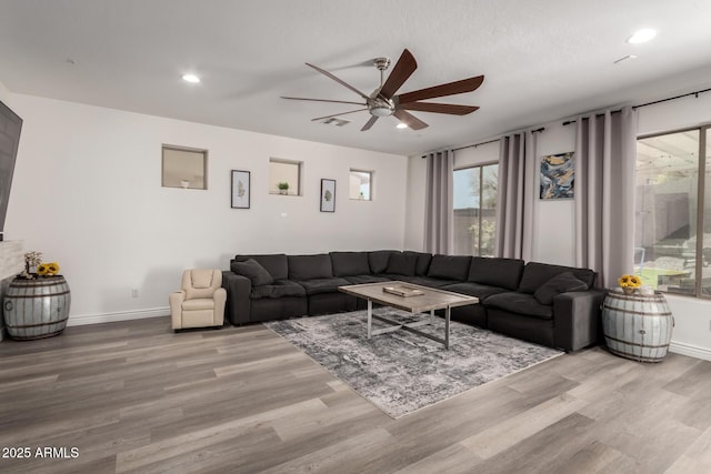 living area with recessed lighting, baseboards, and wood finished floors