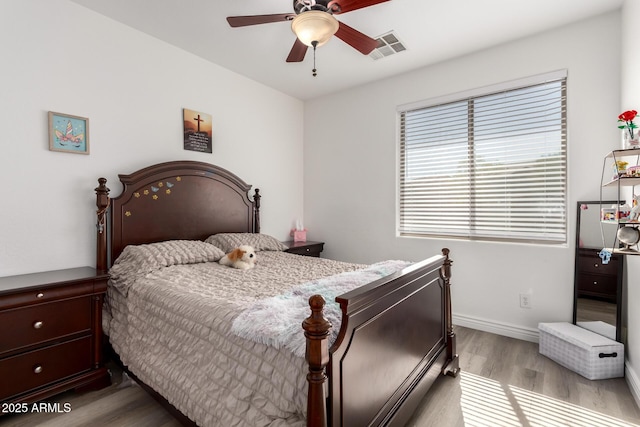 bedroom with visible vents, baseboards, light wood-style floors, and a ceiling fan