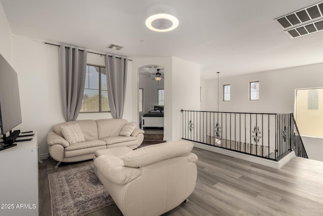 living room featuring ceiling fan, visible vents, and wood finished floors