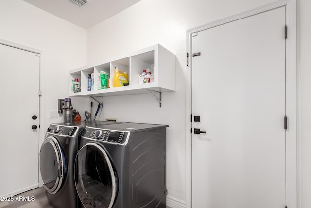 clothes washing area featuring laundry area, wood finished floors, independent washer and dryer, and visible vents