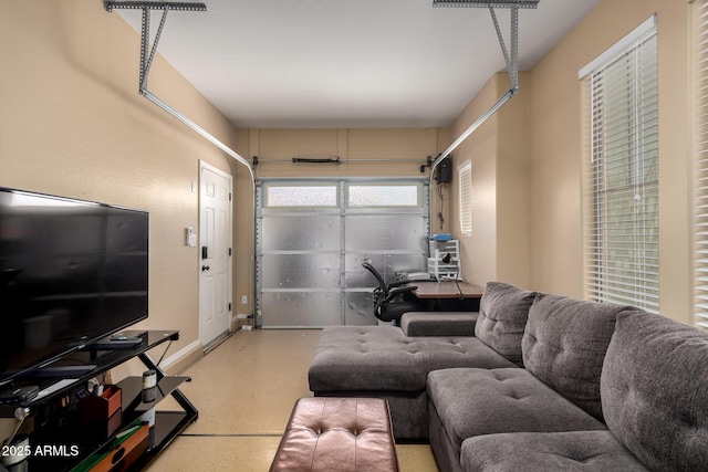 living room featuring baseboards and a garage