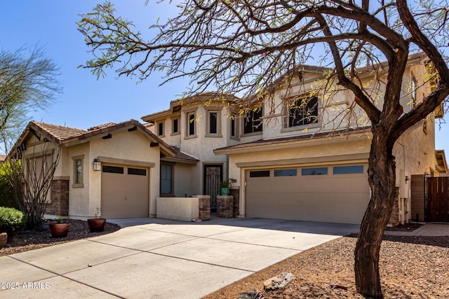 view of front of house with a tiled roof, stucco siding, concrete driveway, and fence