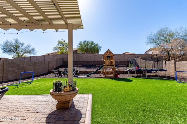 view of yard with a patio area, a trampoline, a fenced backyard, and a playground