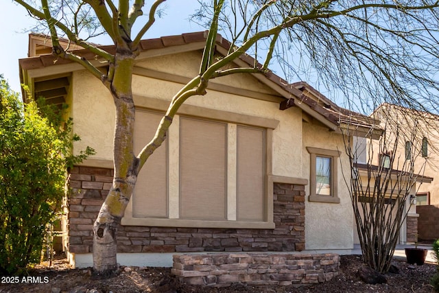 view of side of home featuring stone siding and stucco siding