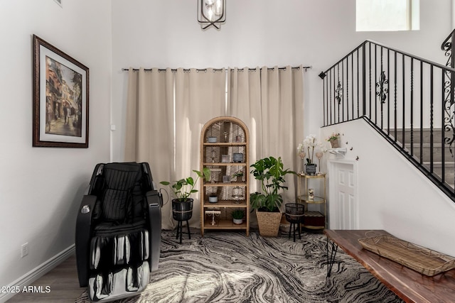 sitting room with baseboards, wood finished floors, and stairs