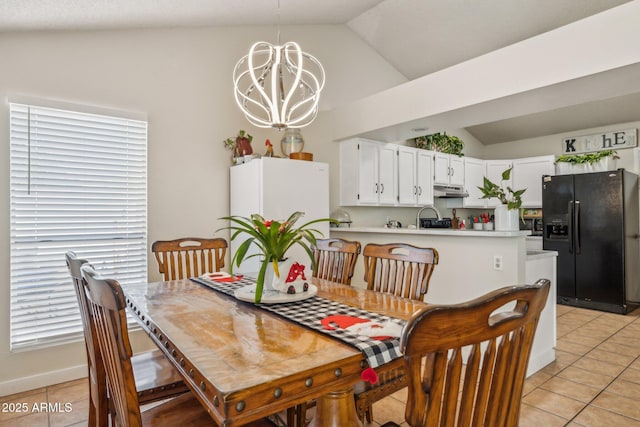 dining area featuring lofted ceiling, light tile patterned floors, and an inviting chandelier