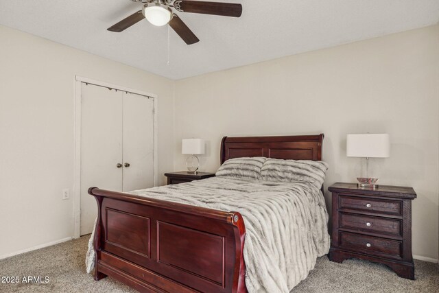 bedroom featuring light colored carpet, a closet, and ceiling fan