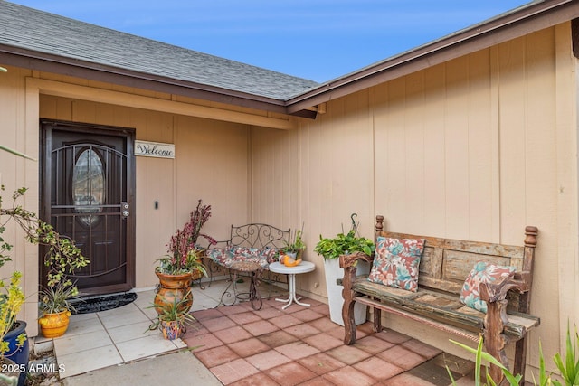 view of exterior entry with a patio area