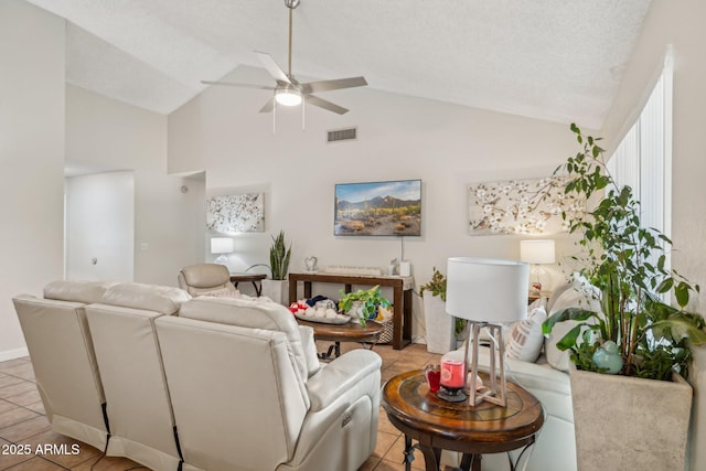 tiled living room featuring ceiling fan, vaulted ceiling, and a textured ceiling