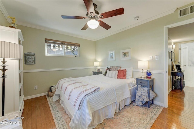 bedroom featuring ceiling fan, light hardwood / wood-style floors, and ornamental molding