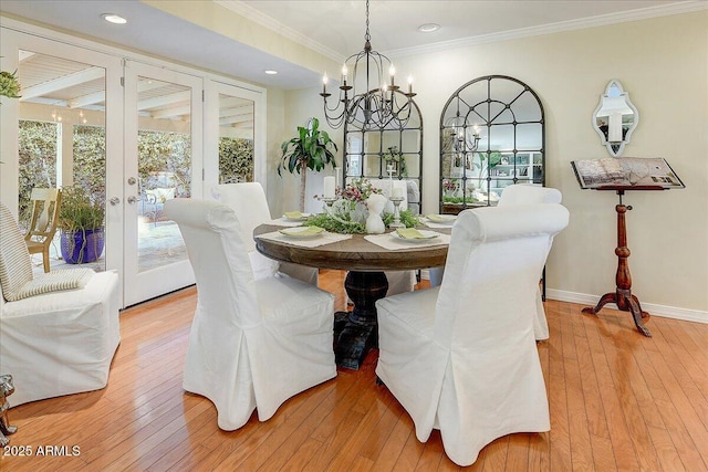 dining room featuring a chandelier, crown molding, light hardwood / wood-style floors, and french doors