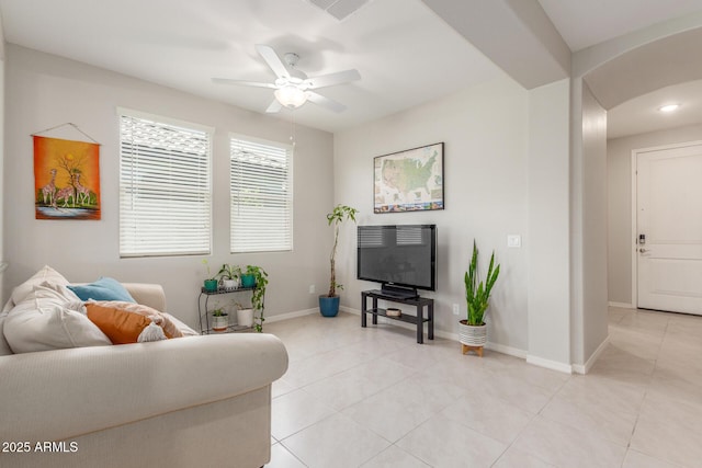686 N 152nd Dr, Goodyear, AZ 85338 - living room with light tile patterned floors, baseboards, a ceiling fan, and arched walkways