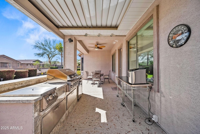 view of patio / terrace featuring ceiling fan, outdoor dining area, a grill, and an outdoor kitchen