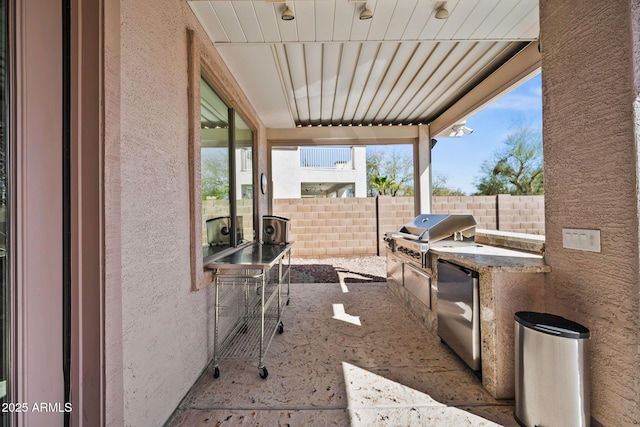 view of patio / terrace featuring an outdoor kitchen, fence, and grilling area