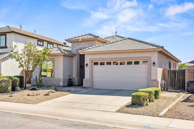 view of front of home featuring a tiled roof, stucco siding, driveway, and a garage