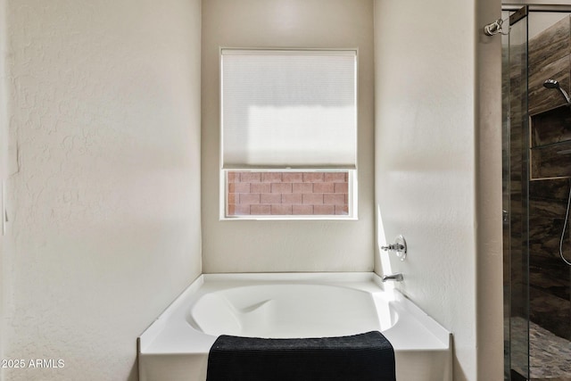 bathroom with a stall shower and a garden tub