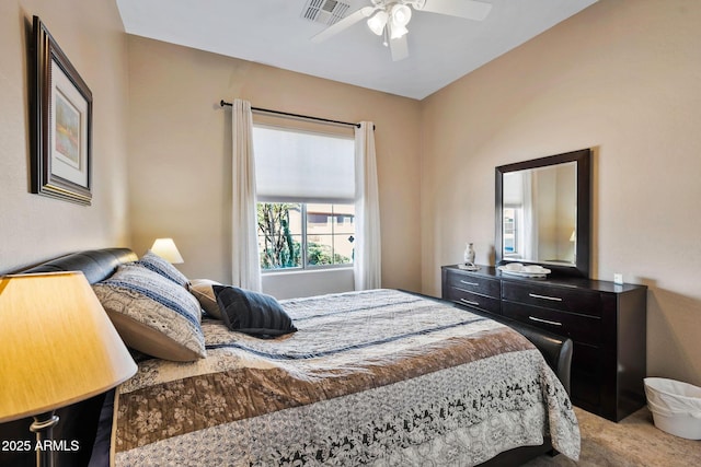 bedroom featuring a ceiling fan, visible vents, and light carpet