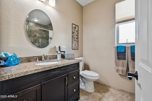 bathroom with baseboards, toilet, a stall shower, tile patterned floors, and vanity