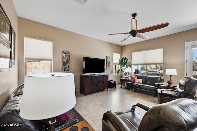 living area featuring light tile patterned floors, visible vents, and a ceiling fan