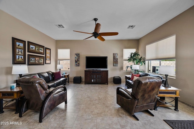 living area with light tile patterned flooring, baseboards, visible vents, and ceiling fan