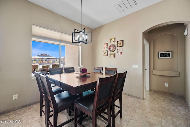 dining room featuring visible vents, a notable chandelier, arched walkways, light tile patterned flooring, and baseboards