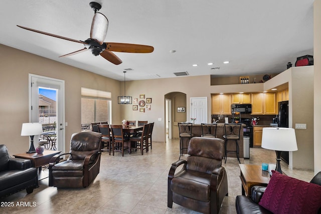 living room featuring visible vents, a ceiling fan, recessed lighting, arched walkways, and light tile patterned floors