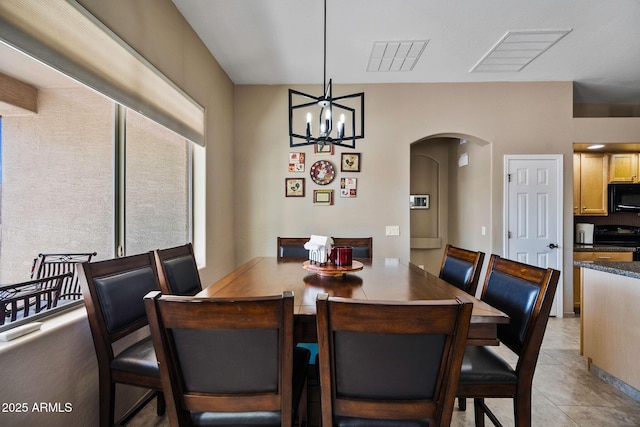 dining room featuring arched walkways, visible vents, a notable chandelier, and light tile patterned floors