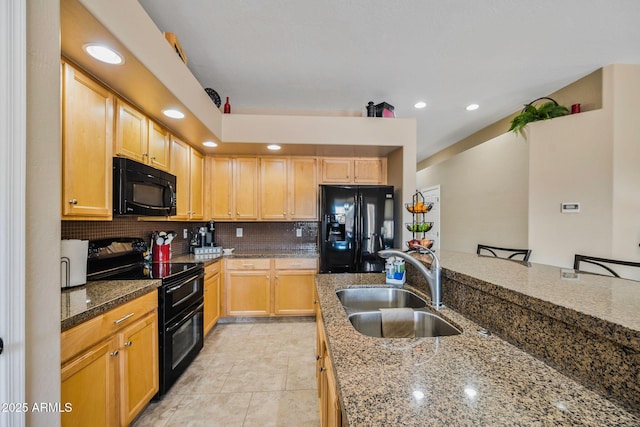 kitchen featuring backsplash, light brown cabinets, black appliances, and a sink