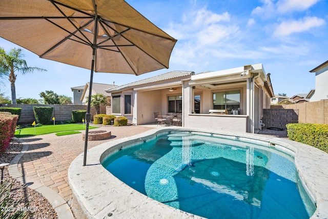 view of pool with a patio, a fire pit, a fenced backyard, and outdoor dry bar