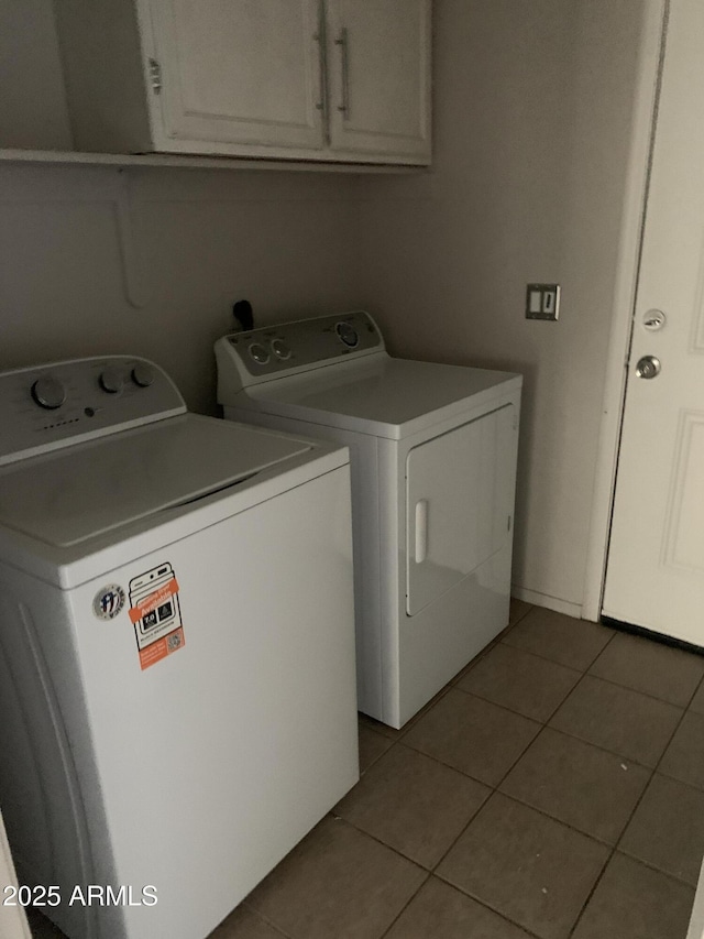 laundry area with washing machine and dryer, cabinet space, and tile patterned floors