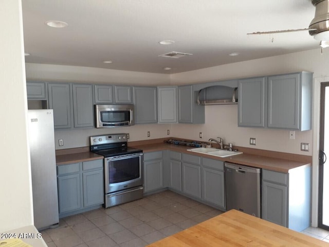 kitchen with a sink, light tile patterned floors, gray cabinets, stainless steel appliances, and visible vents